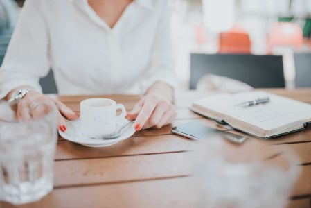 Woman Drinking Coffee with Notepad Free Stock Photo