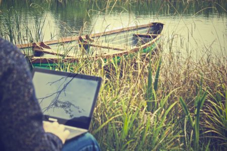 Man on Laptop with Boat Free Stock Photo