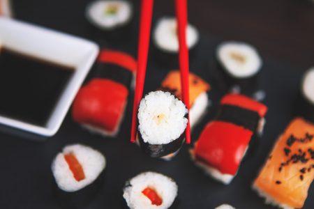 Sushi Held in Chopsticks Free Stock Photo