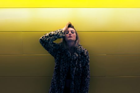 Woman By Yellow Wall Free Stock Photo