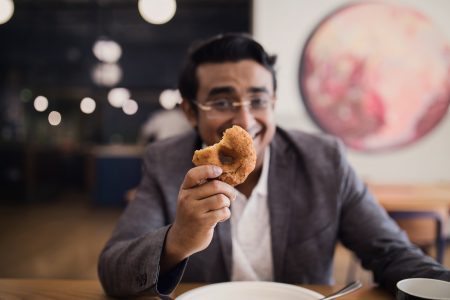 Businessman holding donut Free Stock Photo